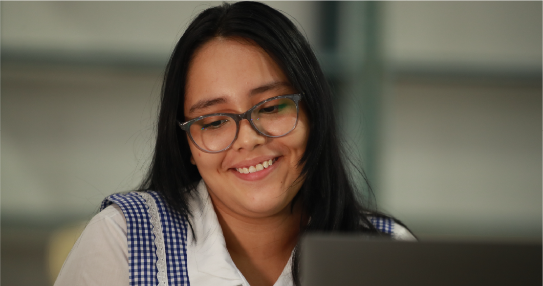 Mujer joven sonriente, con uniforme de colegio.