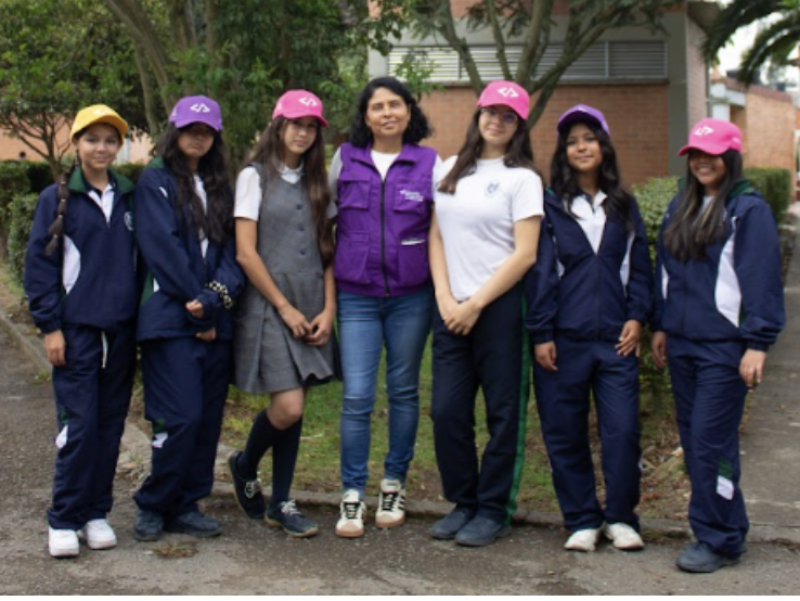 Grupo de estudiantes y docentes posan al aire libre durante una actividad educativa.