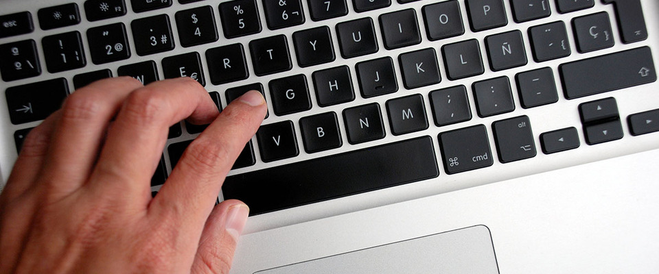 Foto de una mano sobre el teclado de un computador
