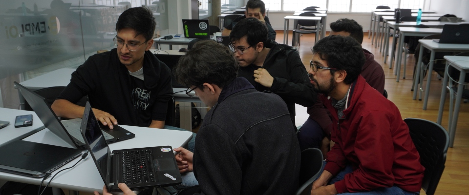 Foto de un grupo de hombres observando un computador Foto de un grupo de hombres observando un computador