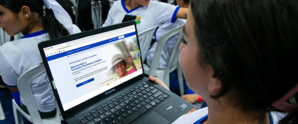 Foto de una estudiante observando un computador portatil Foto de una estudiante observando un computador portatil