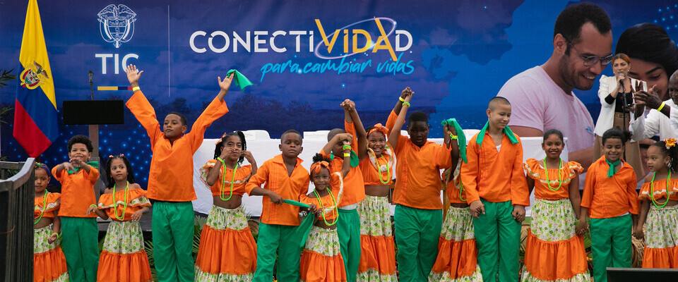 Foto de un grupo de niños con atuendos tipicos de baile en la presentacion de 'Conectividad para Cambiar Vidas'