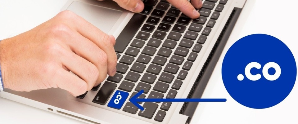Imagen diseñada de una mano sobre un teclado resaltando la tecla .co Imagen diseñada de una mano sobre un teclado resaltando la tecla .co
