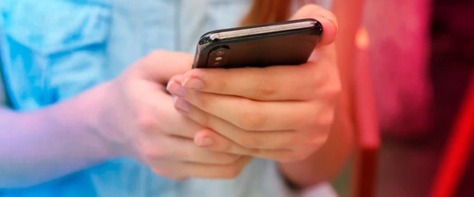 Foto de las manos de un niño sosteniendo un celular Foto de las manos de un niño sosteniendo un celular