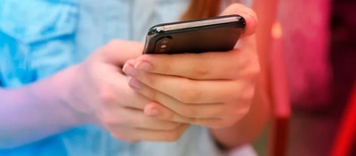Foto de las manos de un niño sosteniendo un celular Foto de las manos de un niño sosteniendo un celular