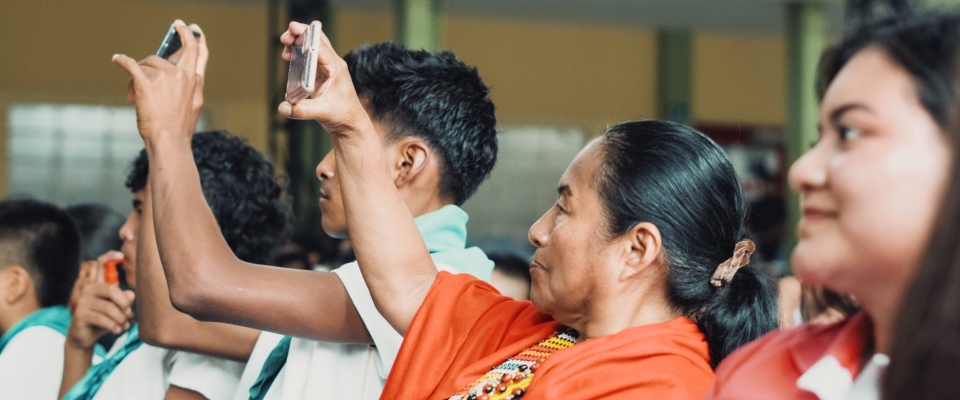 Foto de personas pertenecientes al pueblo indígena sosteniendo un celular