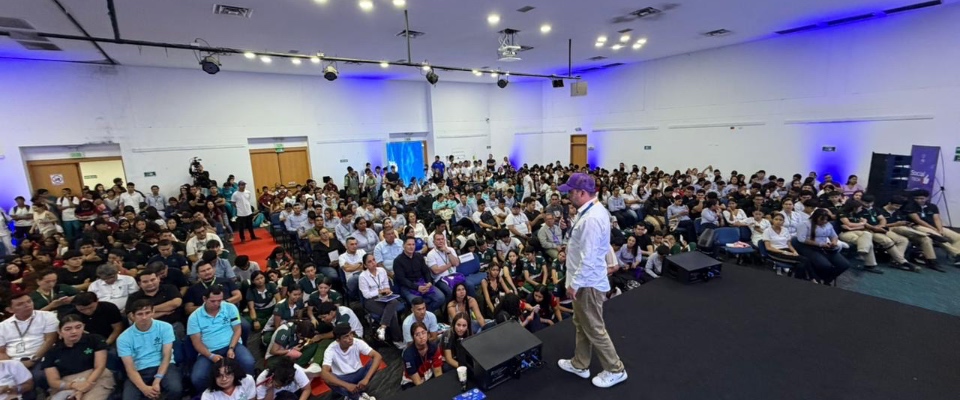 Foto de asistentes y presentador en tarima Foto de asistentes y presentador en tarima