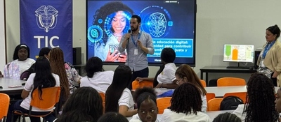 Taller sobre educación digital con estudiantes y facilitadores en aula. Presentación frente a pantalla con contenidos TIC y participación activa del grupo