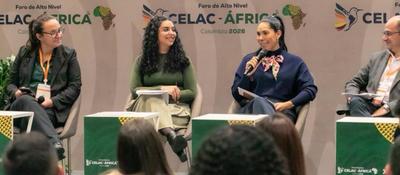 Panel con cuatro personas en escenario del Foro CELAC–África en Colombia; una mujer habla con micrófono mientras dialogan sobre equidad digital