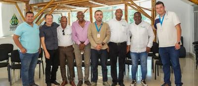 Ocho hombres posan en salón con estructura de madera. Representan MinTIC y Comité Cívico del Chocó tras acordar ruta de conectividad.