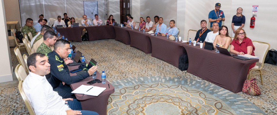 Funcionarios y asistentes se reúnen en salón de hotel en Cartagena, en mesa en U, escuchando agenda sobre conectividad y proyectos