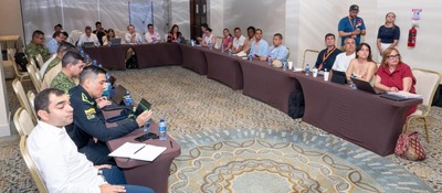 Funcionarios y asistentes se reúnen en salón de hotel en Cartagena, en mesa en U, escuchando agenda sobre conectividad y proyectos