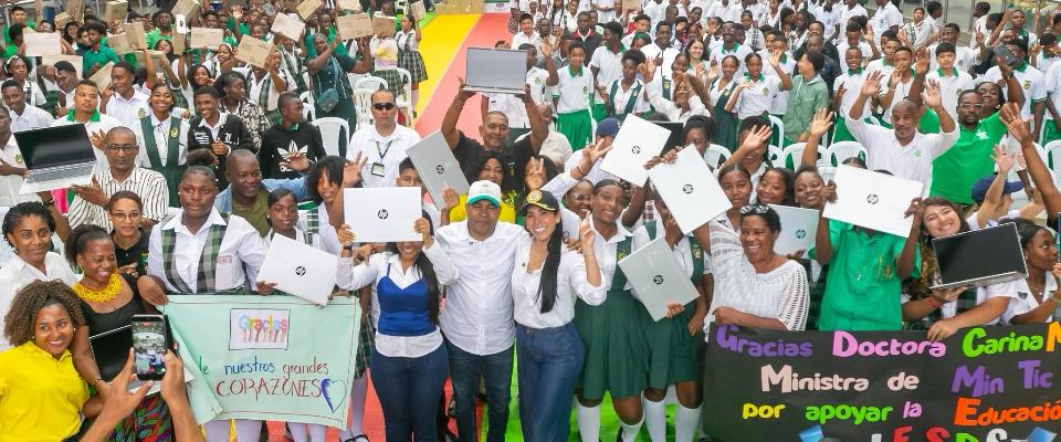 Multitud de estudiantes y adultos en Chocó celebran levantando portátiles; sonríen junto a autoridades en evento de entrega tecnológica