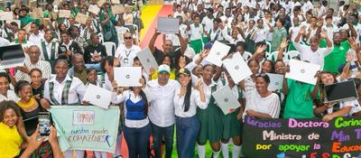 Multitud de estudiantes y adultos en Chocó celebran levantando portátiles; sonríen junto a autoridades en evento de entrega tecnológica