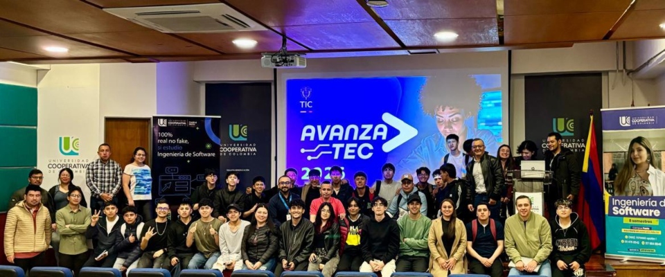 Grupo grande de jóvenes y docentes posa en auditorio universitario frente a pantalla “AvanzaTEC”, en lanzamiento de formación digital con MinTIC e IBM