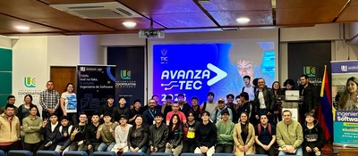 Grupo grande de jóvenes y docentes posa en auditorio universitario frente a pantalla “AvanzaTEC”, en lanzamiento de formación digital con MinTIC e IBM