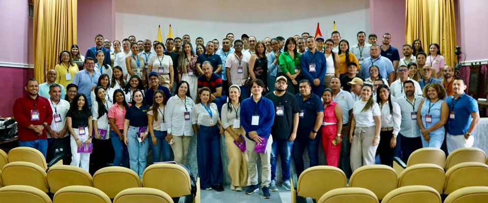 Grupo amplio de personas con escarapelas posa en auditorio; entidades del Caribe reciben capacitación en Política de Gobierno Digital.