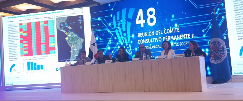 Panel de expertos en escenario presenta datos y mapas en pantalla sobre conectividad; evento oficial sobre avances en zonas rurales