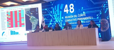 Panel de expertos en escenario presenta datos y mapas en pantalla sobre conectividad; evento oficial sobre avances en zonas rurales