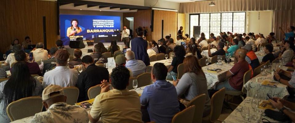 Auditorio lleno escucha a ponente frente a pantalla sobre transformación digital; evento del MinTIC conecta medios comunitarios del Caribe.
