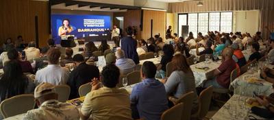 Auditorio lleno escucha a ponente frente a pantalla sobre transformación digital; evento del MinTIC conecta medios comunitarios del Caribe.