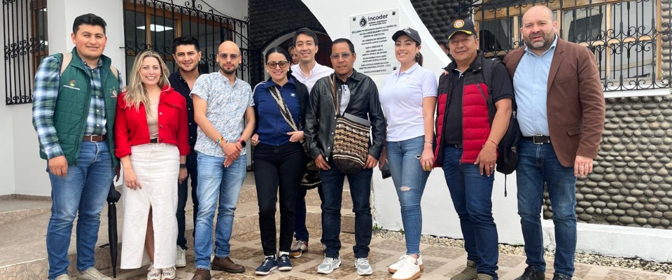 Grupo de diez personas posa frente a edificio institucional; escena vinculada al apoyo del MinTIC a la comunicación indígena.