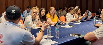 Funcionarios sentados en mesa de trabajo con portátiles y documentos; participan en seguimiento a compromisos con pueblo raizal en San Andrés.