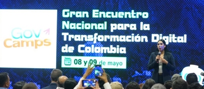 Auditorio lleno durante GovCamp 2026. En pantalla gigante anuncian encuentro nacional sobre transformación digital en Colombia.