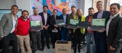 Grupo de líderes posa con computadores portátiles en evento sobre innovación territorial y formación STEAM en Bogotá.