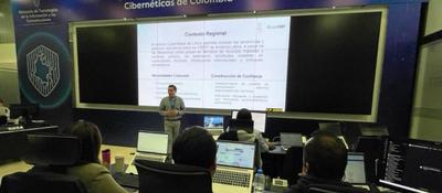 Funcionarios observan presentación técnica en centro de monitoreo digital durante preparación de conectividad electoral 2026