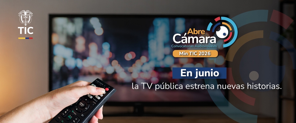 Mano sostiene un control remoto frente a un televisor. Promoción de Abre Cámara anuncia nuevas historias en la TV pública en junio