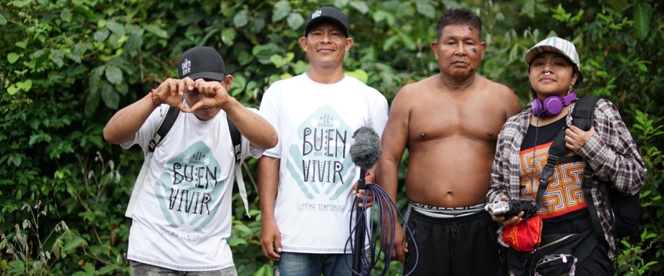 Equipo de producción y miembro de comunidad indígena posan en entorno selvático durante grabación de El Buen Vivir