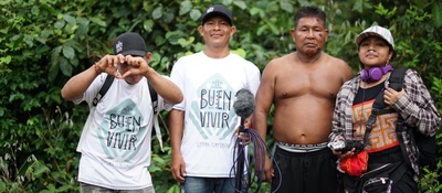 Equipo de producción y miembro de comunidad indígena posan en entorno selvático durante grabación de El Buen Vivir