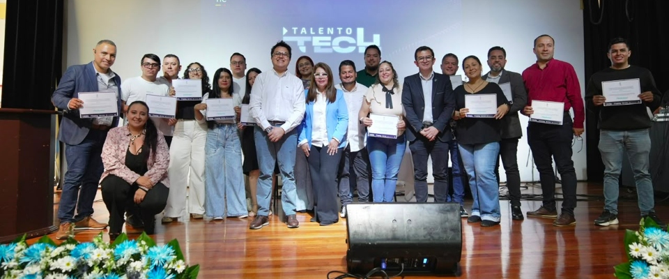 Grupo de graduados y directivos posa en escenario con certificados durante el cierre de Talento Tech en Risaralda.