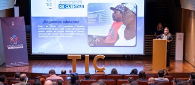 Auditorio con asistentes frente a una presentación del sector TIC sobre avances en conectividad y transformación digital