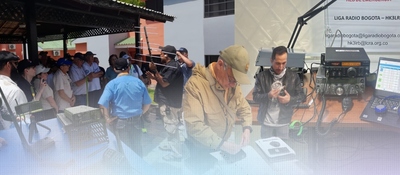 Varias personas se reúnen al aire libre; al centro, un hombre revisa equipo. A la derecha, otra persona opera una radio