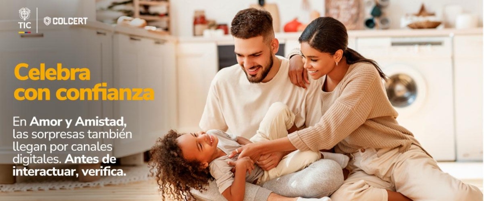 Tres personas sentadas en una sala: dos adultos sonríen junto a un niño. Al fondo hay muebles y electrodomésticos.