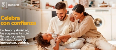 Tres personas sentadas en una sala: dos adultos sonríen junto a un niño. Al fondo hay muebles y electrodomésticos.